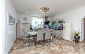 a kitchen with a table and chairs and a refrigerator at Stunning Apartment In Buje With House A Panoramic View in Buje