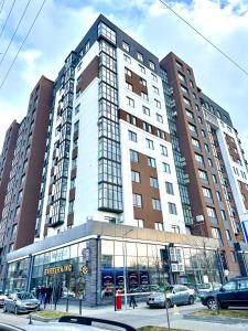un grande edificio con macchine parcheggiate di fronte di Modern apartments in the city center with a view of the city a Rivne