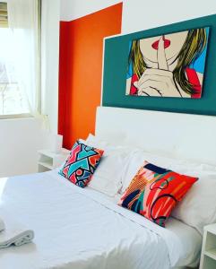 a bedroom with a white bed with a painting on the wall at Mia House Roma in Rome