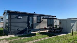 米德尔克尔克Stacaravan De Maravan的蓝色的小房子,配有桌子和椅子