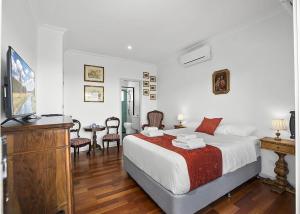 a bedroom with a bed and a television in it at Ciao Korora The Classic in Kororo Basin