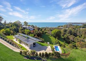 an aerial view of a house with the ocean in the background at Ciao Korora The Classic in Kororo Basin