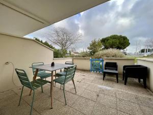 een patio met een tafel en stoelen en een piano bij Appartement Saint-Georges-d'Oléron, 2 pièces, 4 personnes - FR-1-246A-222 in Saint-Georges-dʼOléron