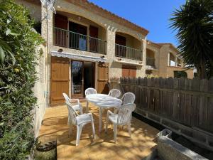 patio ze stołem, krzesłami i ogrodzeniem w obiekcie Villa T3 avec garage, terrasse, piscine et Wifi - 6 couchages à Saint-Cyprien, proche plage et commerces - FR-1-106-89 w mieście Saint-Cyprien