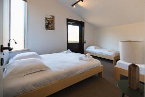 een slaapkamer met 2 bedden en een raam bij Village du Caillou in Dinant
