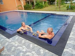 two people are sitting in a swimming pool at Serenity Lake Resort Yala in Tissamaharama