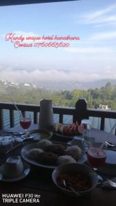 Kandy Unique Hotel في كاندي: طاولة مع أطباق من الطعام وكؤوس من النبيذ