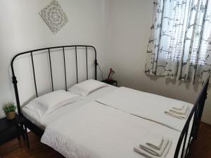 Schlafzimmer mit einem Bett mit weißer Bettwäsche und einem Fenster in der Unterkunft Istrian old town apartment in Koper