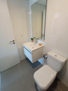 uma casa de banho branca com um WC e um lavatório em Apartamento nuevo, centrico y con vista a la bahia em Montevidéu