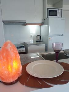 a plate and a glass of wine on a kitchen counter at Apartamento nuevo, centrico y con vista a la bahia in Montevideo
