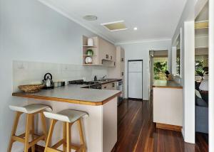 a kitchen with a island with two bar stools at Nonna and Pops in Mylestom