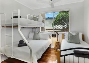 two white bunk beds in a room with a window at Nonna and Pops in Mylestom