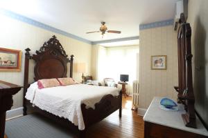 um quarto com uma cama grande e uma janela em Beauclaires Bed & Breakfast em Cape May
