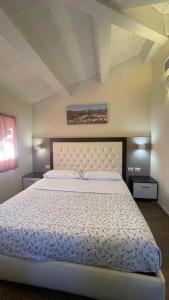 um quarto com uma cama grande e uma colcha branca em Modus Vivendi - Room E Relax em Brisighella