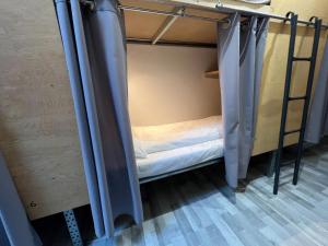 a small bed in a small room with curtains at The Old Factory in Copenhagen