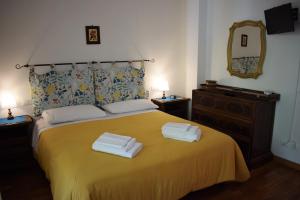 a bedroom with a yellow bed with two towels on it at La Casa di LiLi in Pontassieve