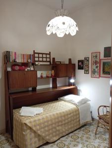 a bedroom with a bed and a chandelier at Casa San Carlo Affittacamere Foligno in Foligno