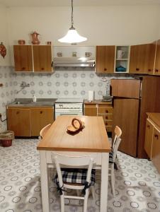 a kitchen with a wooden table with two chairs at Casa San Carlo Affittacamere Foligno in Foligno