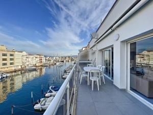 einen Balkon mit einem Tisch und Booten im Wasser in der Unterkunft Port Moxo 78 -22 in Empuriabrava