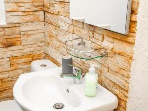 een badkamer met een witte wastafel en een spiegel bij Ferienwohnungen Merl in Zell an der Mosel