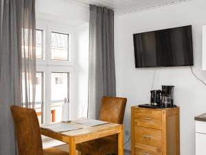ein Esszimmer mit einem Tisch und einem Fernseher an der Wand in der Unterkunft Ferienwohnungen Merl in Zell an der Mosel