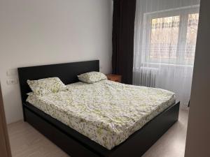 Schlafzimmer mit einem Bett und einem Fenster in der Unterkunft Apartament 2 camere in Bukarest