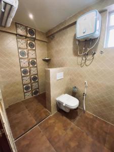 a bathroom with a toilet and a phone on the wall at HOTEL TOUCHWOOD in Visakhapatnam