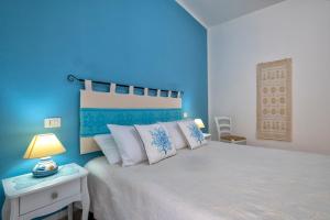 Casa Vacanze San Michele في ألغيرو: غرفة نوم زرقاء مع سرير بجدار ازرق