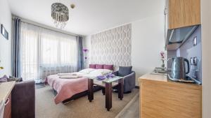 Sala de estar con cama y mesa en Apartamenty Sun & Snow Arka Spa I, en Kołobrzeg