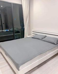 1 cama blanca en un dormitorio con ventana en The Room Phyathai en Bangkok