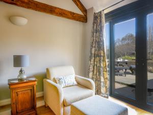 a living room with a chair and a sliding glass door at Ware Barn Cottage in Lyme Regis
