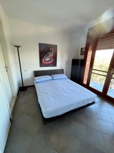 una camera da letto con un letto e un dipinto sul muro di Appartamento in centro con terrazze e parcheggio gratuito a Lignano Sabbiadoro