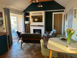 a living room with a table and chairs and a fireplace at Osprey Hide in Forres