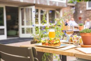 a table with a plate of food and a glass of beer at blooming in Bergen
