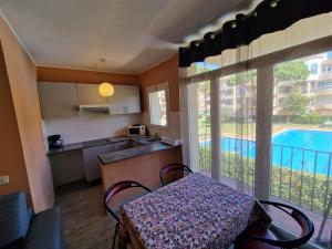 una cucina con tavolo e una cucina con piscina di Apartamento Gran Reserva Beach-3 a Empuriabrava