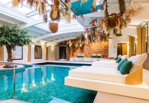 a hotel pool with white beds and a swimming pool at Atlantic Hôtel & Spa in Les Sables-d'Olonne