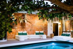 uma piscina com mobiliário branco ao lado de uma parede de tijolos em Atlantic Hôtel & Spa em Les Sables-dʼOlonne