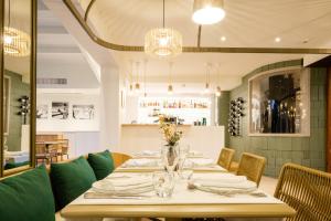 a dining room with a table and green walls at Atlantic Hôtel & Spa in Les Sables-d'Olonne