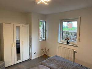 Un dormitorio con una cama y dos ventanas. en Apartment im Grünen bei Koblenz, en Vallendar