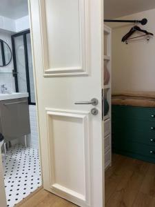 a white door in a bathroom with a sink at Charm'in Champigny: Studio cosy, détente & travail in Champigny-sur-Marne