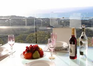 - une table avec une assiette de fruits et une bouteille de vin dans l'établissement Belvedere, à Kororo Basin
