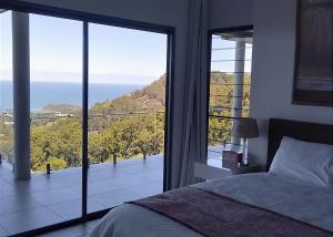 a bedroom with a bed and a view of the ocean at Belvedere in Kororo Basin
