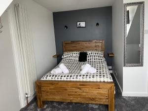 a bedroom with a wooden bed with a mirror at St Georges in St Peter Port