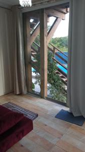 a room with a large glass door to a balcony at Pousada Jolie Maison in São Francisco do Sul