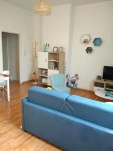 ein Wohnzimmer mit einem blauen Sofa und einem Stuhl in der Unterkunft Appartement calme proche de la Loire in Saumur