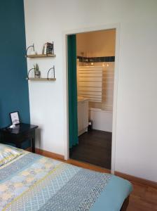 a bedroom with a bed and a bathroom at Appartement calme proche de la Loire in Saumur