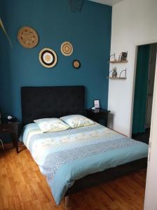 a bedroom with a bed with a blue wall at Appartement calme proche de la Loire in Saumur