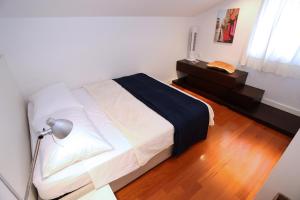 ein Schlafzimmer mit einem Bett und einem Schreibtisch mit einer Lampe in der Unterkunft Villa Belvedere apartment 4 in Murter