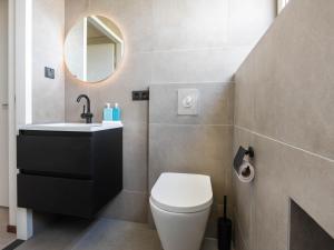 a bathroom with a toilet and a sink and a mirror at Antibes 240 - Kustpark Village Scaldia in Hoofdplaat +21 photos