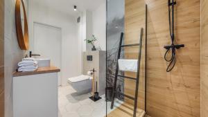 uma casa de banho com um WC e uma porta de duche em vidro. em Sun & Snow prywatne apartamenty w obiekcie Nautikka Resort em Krynica Morska